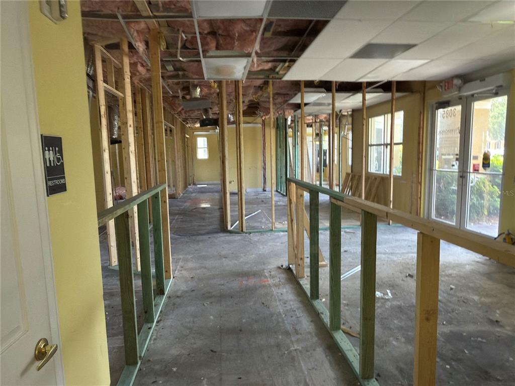 An interior view of a commercial space under renovation with exposed wall studs and insulation — 3075 BOBCAT VILLAGE CENTER ROAD, NORTH PORT, FL