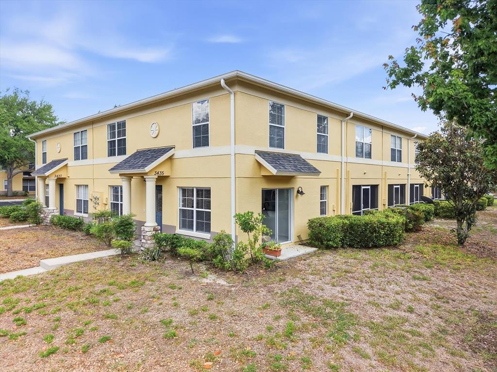A two-story yellow stucco apartment building features a covered entryway and a screened patio — 3435 CASTLE STONE COURT, VALRICO, FL
