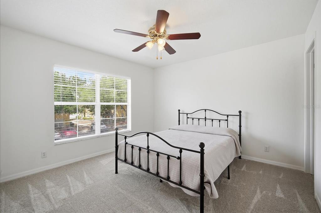 A bedroom with white walls, beige carpet, a metal bed frame, and a ceiling fan — 3435 CASTLE STONE COURT, VALRICO, FL