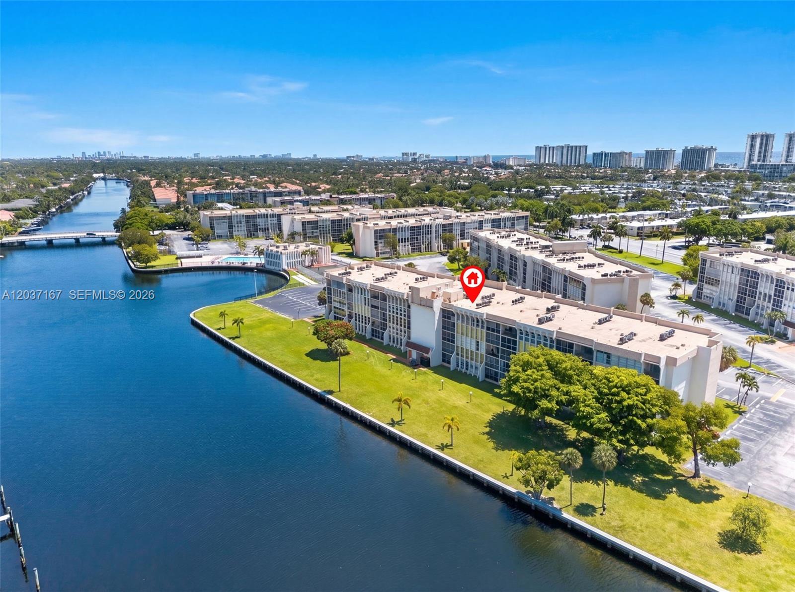 An aerial view shows a multi-story apartment building situated along a canal — 601 Three Islands Blvd # 403, Hallandale Beach FL 33009, HALLANDALE BEACH, FL