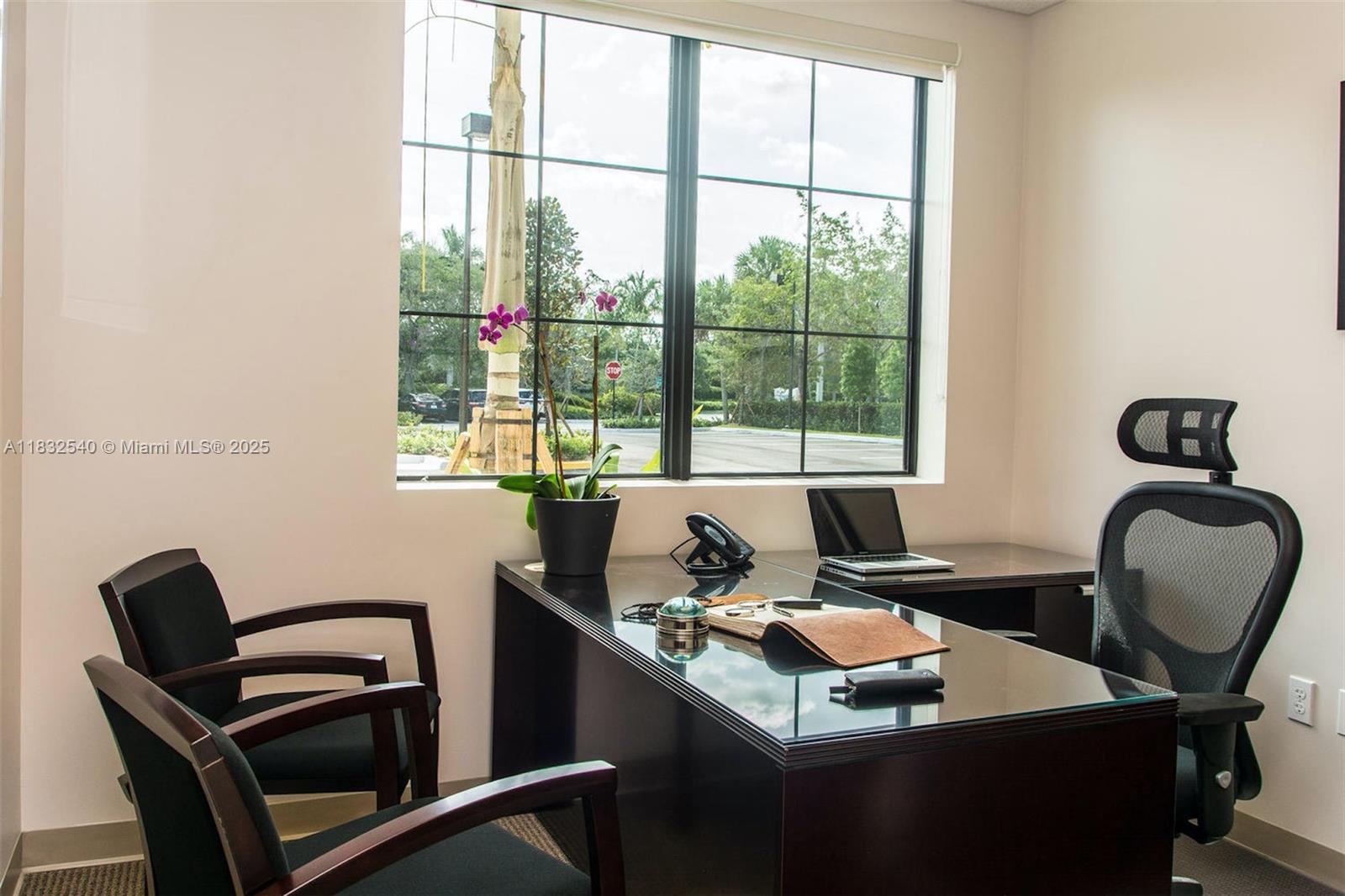 An office features a dark desk, two guest chairs, a mesh chair, and a large window — 1555 Bonaventure Blvd # 2010, Weston FL 33326, WESTON, FL