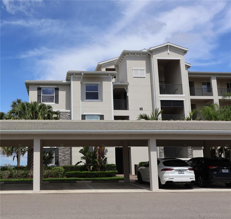 A multi-story apartment building with a covered parking structure in the foreground — 920 TIDEWATER SHORES LOOP UNIT 301, BRADENTON, FL