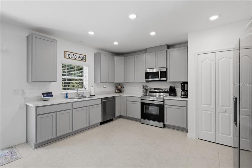 A kitchen with gray cabinets, stainless steel appliances, and white countertops — 4856 STEPHENS STREET, HASTINGS, FL