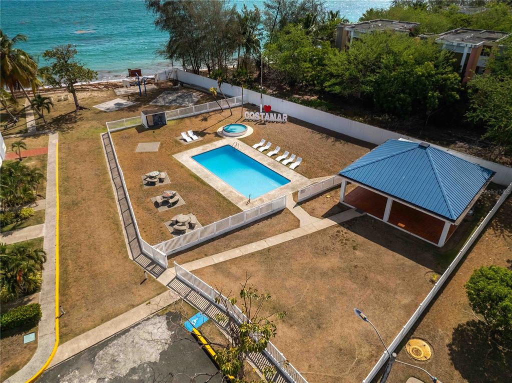 A bedroom with a white bed, tile floors, and a sliding door leading to a balcony — 1 CALLE EL CHARLIE UNIT CO-308, LOIZA, PR