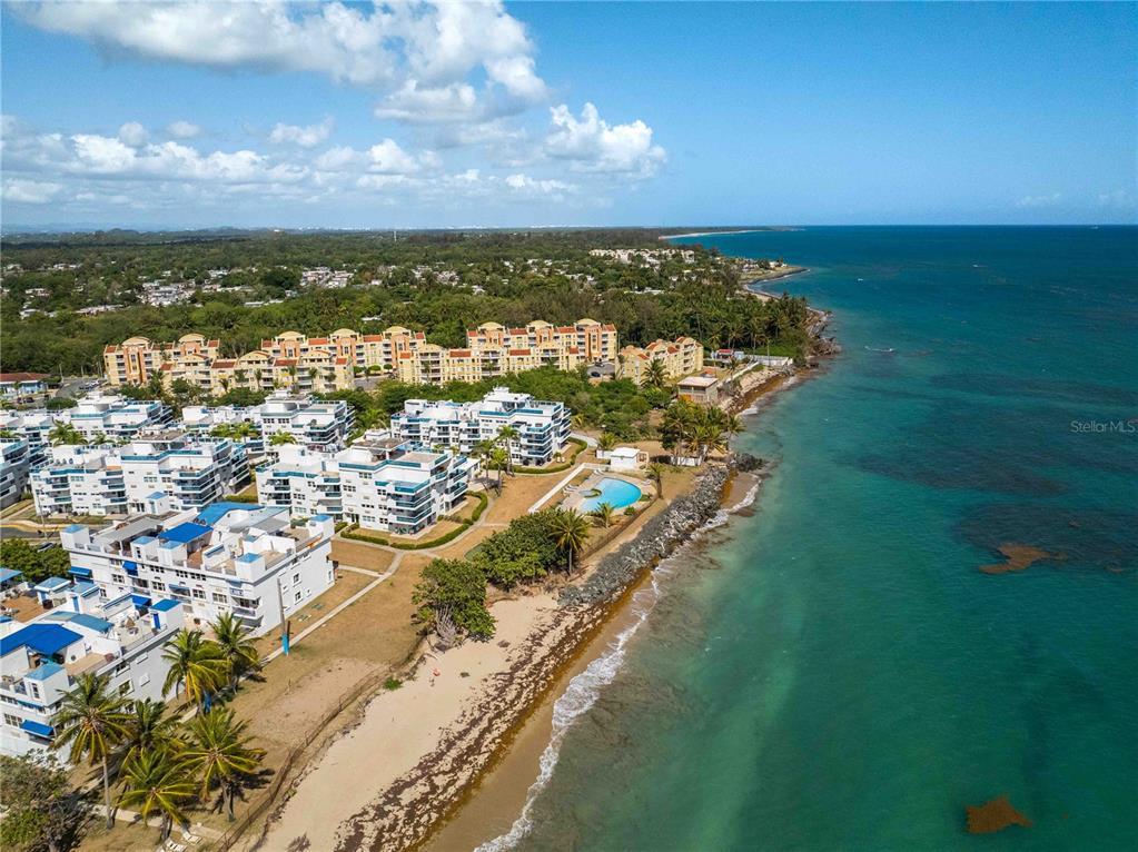 A bedroom with a queen bed, tiled floors, a ceiling fan, and a balcony view — 1 CALLE EL CHARLIE UNIT CO-308, LOIZA, PR