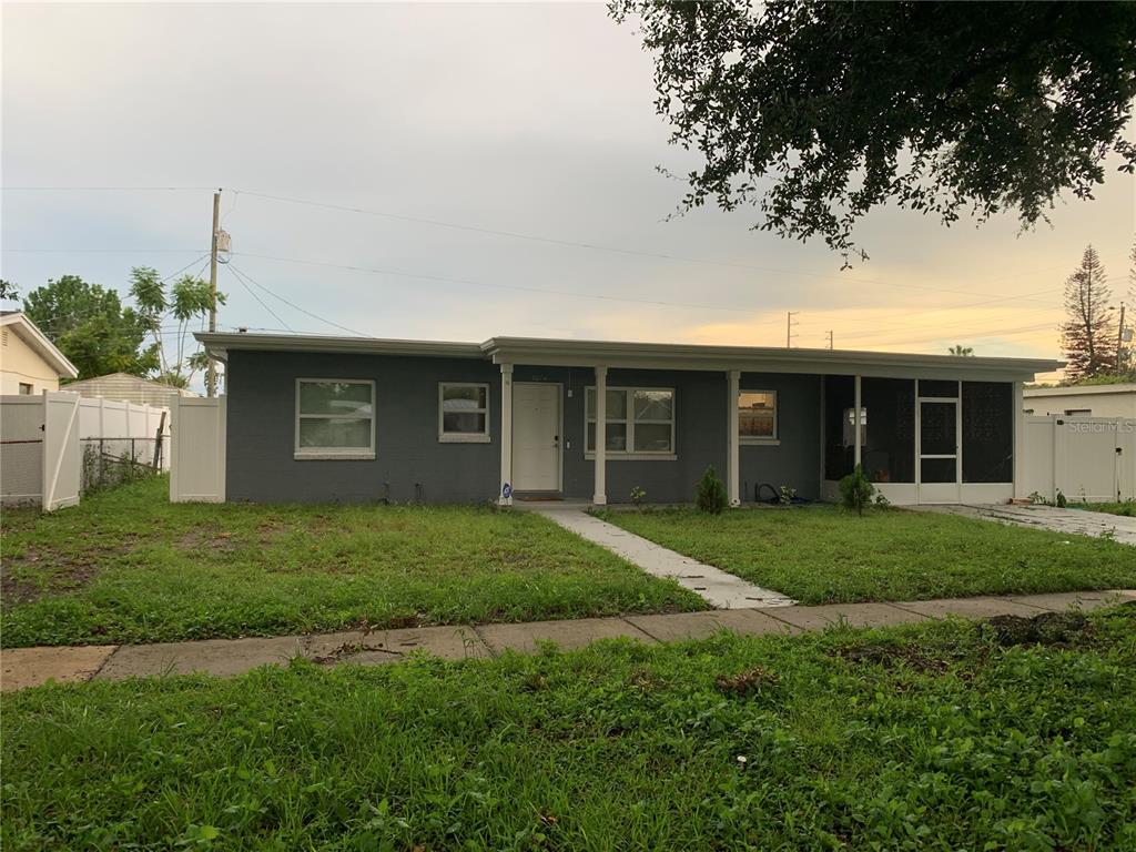 A single-story gray house with a front porch and a screened-in area — 7014 HERSHEY WAY, ORLANDO, FL