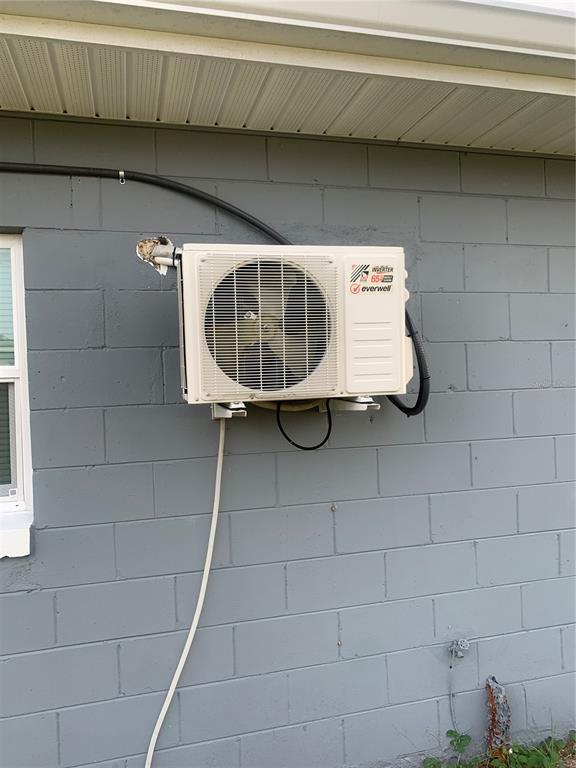 An exterior view of a wall-mounted Everwell mini-split air conditioning unit on a gray wall — 7014 HERSHEY WAY, ORLANDO, FL