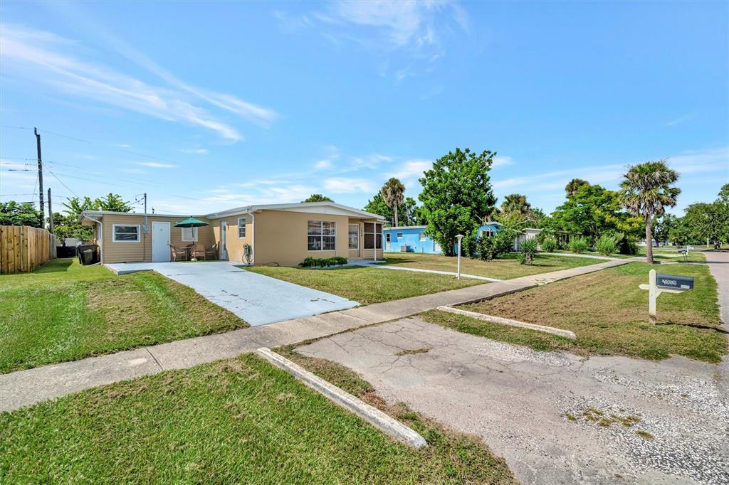 A tan single-story house with a blue driveway and a small patio area — 7959 HYDE PARK AVENUE, NORTH PORT, FL