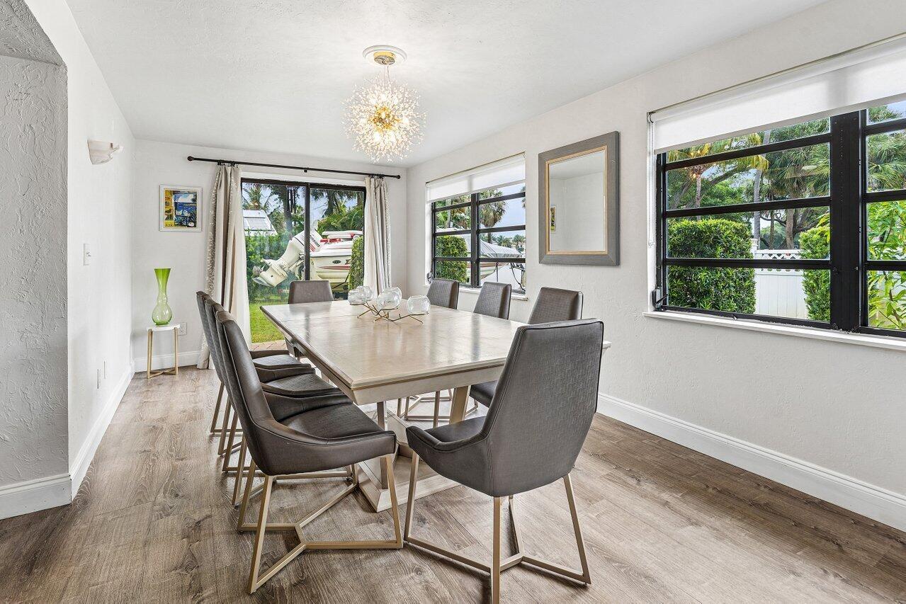 A dining room features a light wood table, grey chairs, and a modern chandelier — 2101 N Palm Circle, North Palm Beach FL 33408, NORTH PALM BEACH, FL