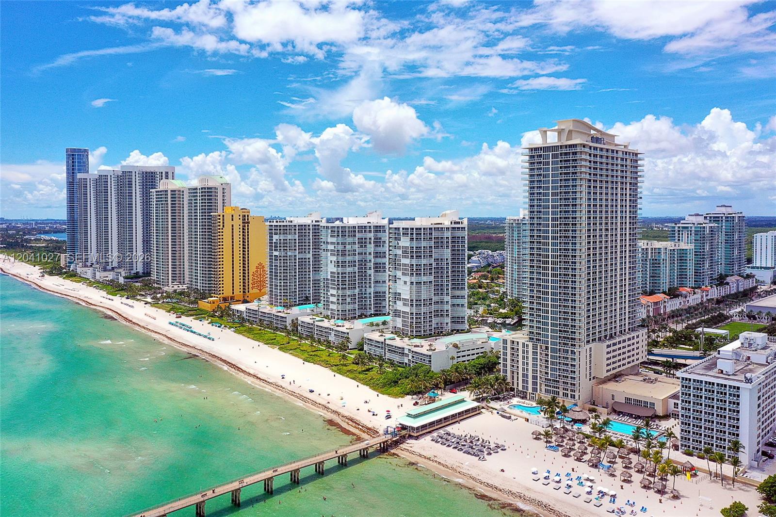 An aerial view of a sandy beach lined with high-rise residential buildings and a pier — 16699 Collins Ave # 3309, Sunny Isles Beach FL 33160, SUNNY ISLES BEACH, FL