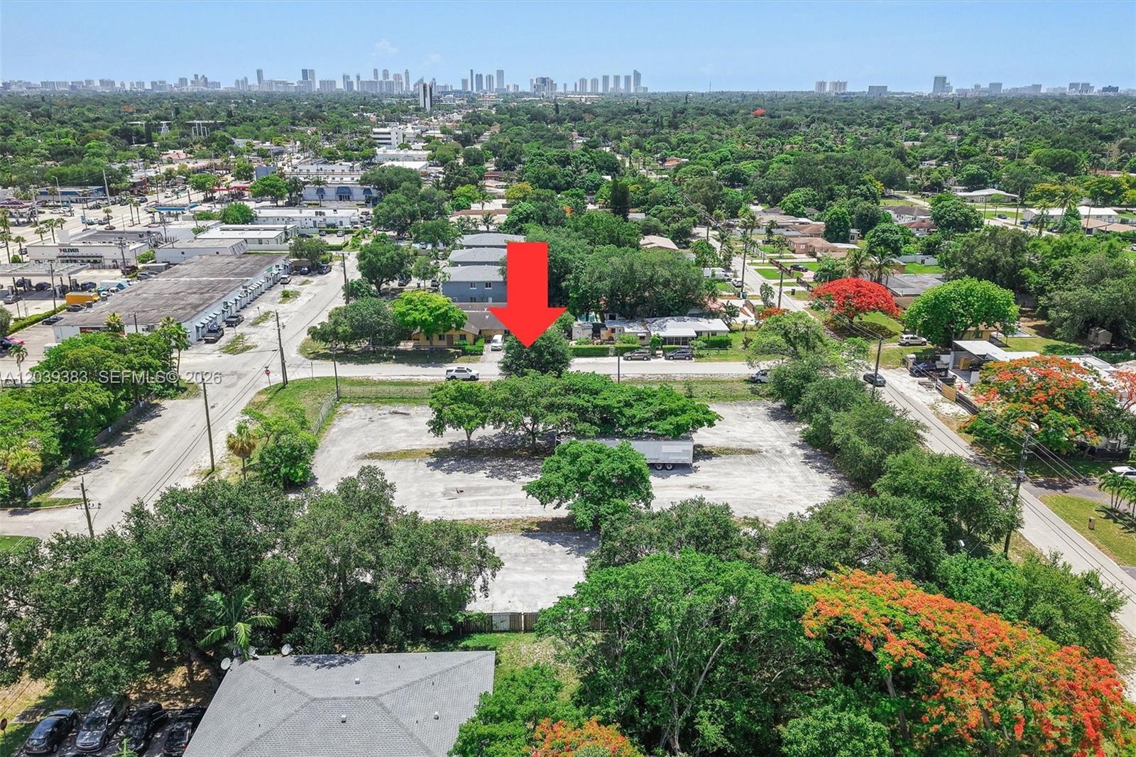 An aerial view shows a paved lot with trees and a trailer near residential buildings — 1st ave NW 166 st, Miami FL 33169, MIAMI, FL