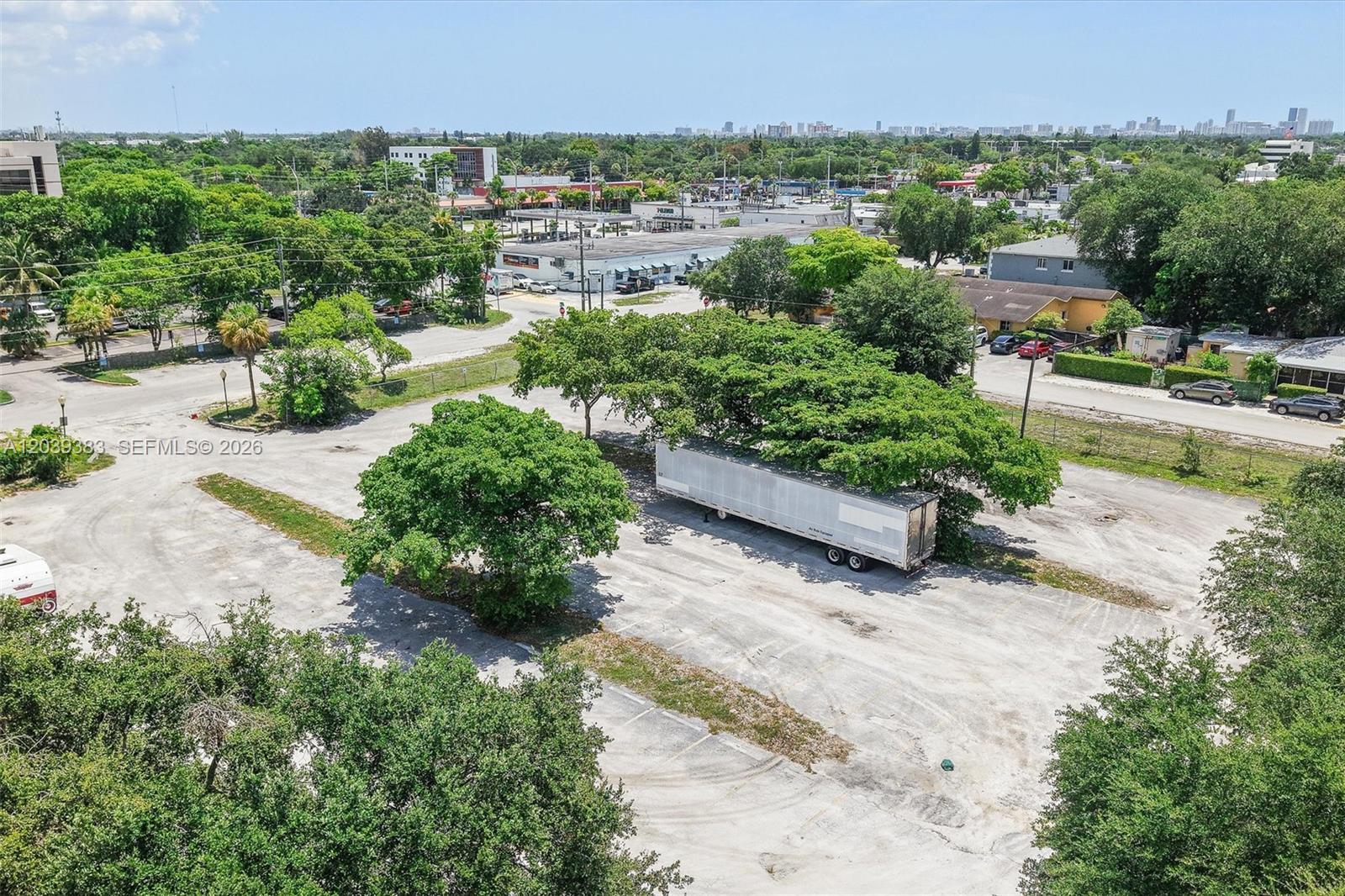 An aerial view shows a large, paved parking lot with several trees and a semi-trailer — 1st ave NW 166 st, Miami FL 33169, MIAMI, FL
