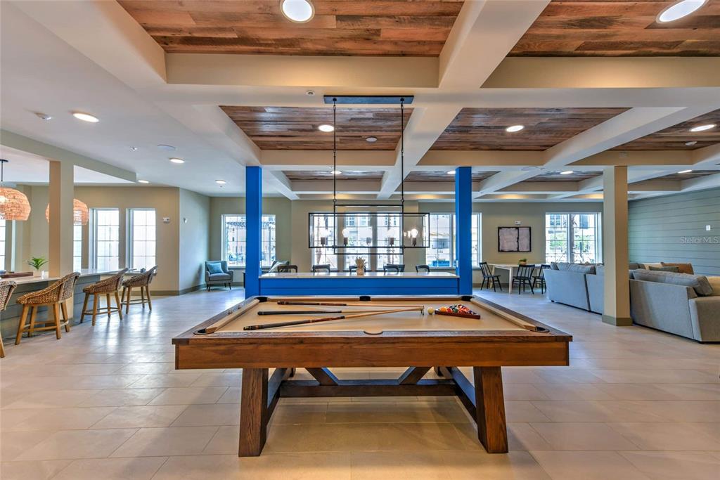 A spacious recreation room features a pool table, wood-paneled ceiling, and blue support columns — 6629 DAN DICIOLLA DRIVE UNIT B2, WILDWOOD, FL