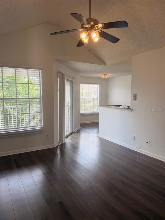 A living room with dark wood-look flooring, a vaulted ceiling, and a ceiling fan — 11568 WESTWOOD BOULEVARD UNIT 1034, ORLANDO, FL