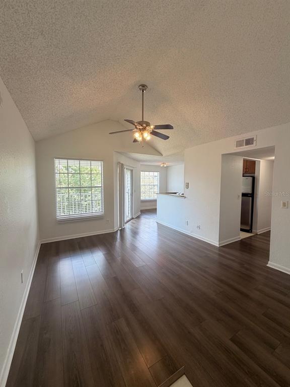 An open living area features vaulted ceilings, wood-look flooring, and a ceiling fan — 11568 WESTWOOD BOULEVARD UNIT 1034, ORLANDO, FL