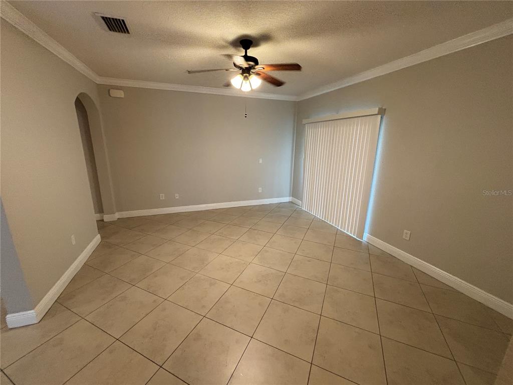 An empty room with beige walls, tile flooring, a ceiling fan, and sliding glass doors — 3719 S LAKE ORLANDO PARKWAY UNIT 05, ORLANDO, FL
