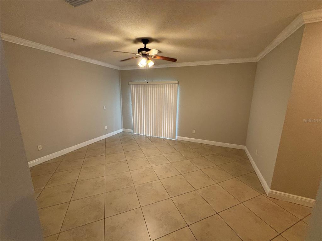 An empty room features beige tile flooring, light-colored walls, and a ceiling fan — 3719 S LAKE ORLANDO PARKWAY UNIT 05, ORLANDO, FL