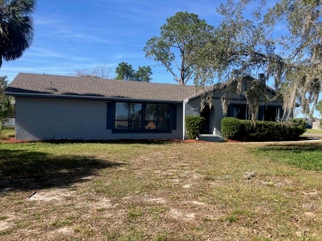 A single-story house with a gray exterior, a shingled roof, and a large front yard — 5241 MAGNOLIA TERRACE, FRUITLAND PARK, FL