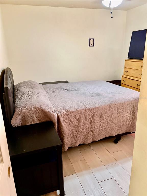 A bedroom features a bed with a quilted cover, a dark nightstand, and a wooden dresser — 1830 WARRINGWOOD DRIVE UNIT B3, ORLANDO, FL