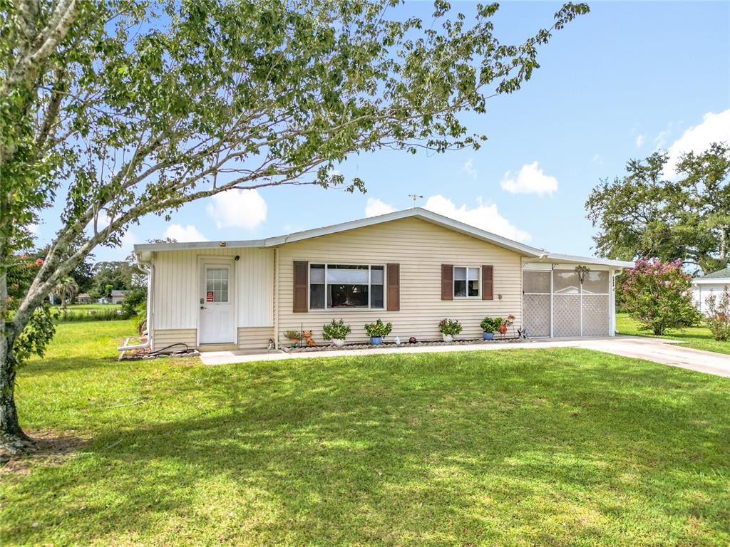 A single-story house with beige siding, a white front door, and a carport — 6468 SW 107TH PLACE, OCALA, FL