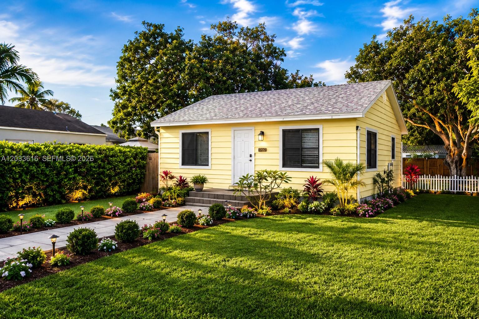 A yellow, single-story house with a white door and a paved walkway in the front yard — 2330 Scott St, Hollywood FL 33020, HOLLYWOOD, FL