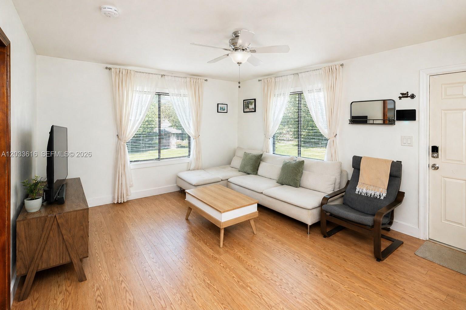 A living room features a sectional sofa, coffee table, armchair, and wood-look flooring — 2330 Scott St, Hollywood FL 33020, HOLLYWOOD, FL