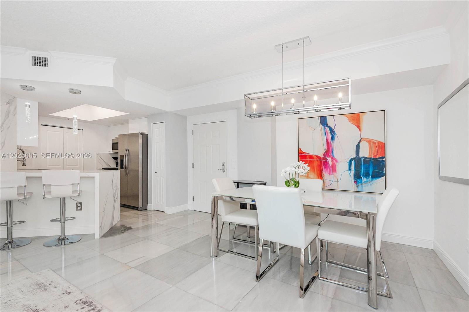 A modern dining area and kitchen feature white furniture, marble-look tile floors, and stainless appliances — 2000 N Bayshore Dr # 619, Miami FL 33137, MIAMI, FL