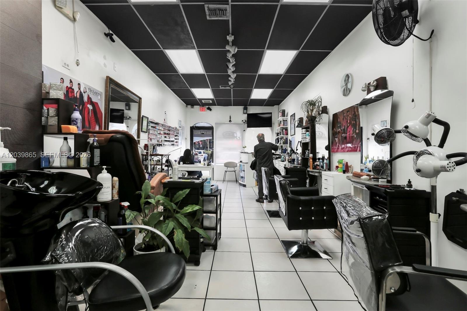 A hair salon interior features black ceiling tiles, white tiled floors, and multiple styling stations — 5233 NW 79th Ave, Doral FL 33166, DORAL, FL
