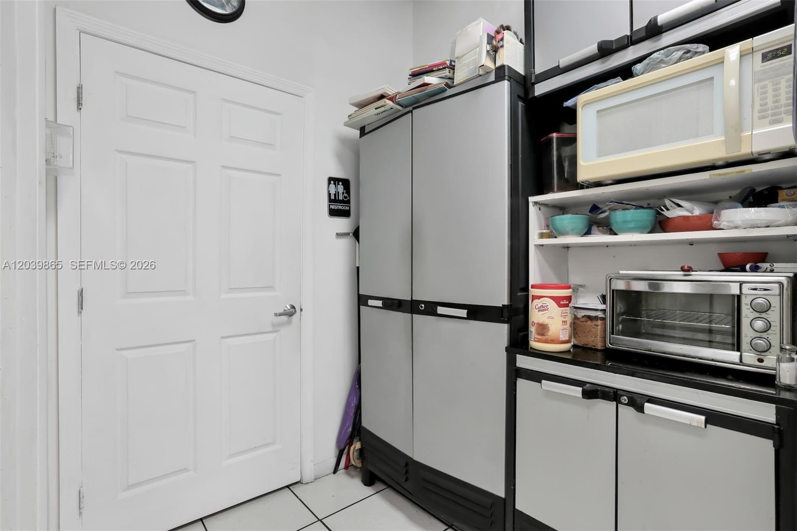 A kitchen area features a white door, a tall storage cabinet, and a microwave oven — 5233 NW 79th Ave, Doral FL 33166, DORAL, FL