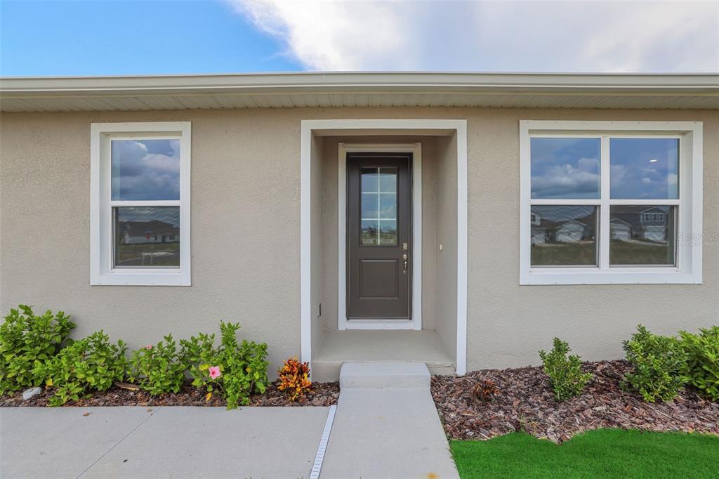 The exterior of a house features a dark front door flanked by two windows — 7530 SEA OAK COURT, PARRISH, FL