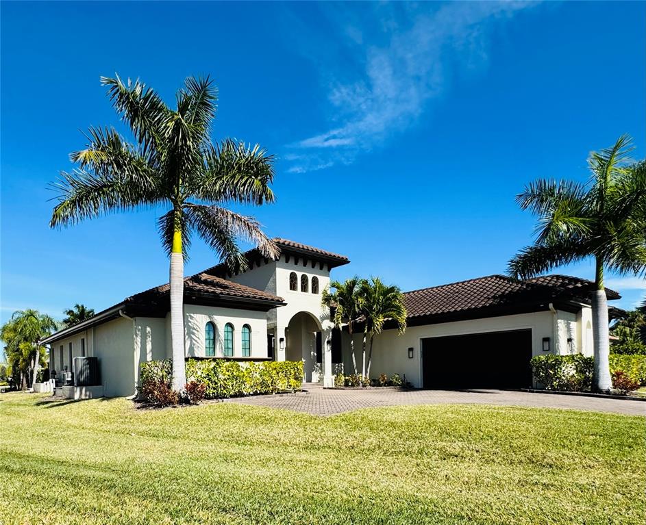 A single-story stucco house with a tile roof, arched windows, and palm trees in front — 8533 S LAKE CIRCLE, FORT MYERS, FL