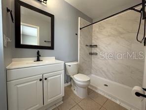 A bathroom features a white vanity, a mirror, a toilet, and a tiled shower stall — 13403 FAIRWAY GLEN DRIVE UNIT 204, ORLANDO, FL