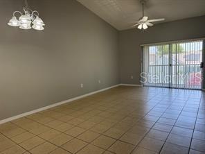 A spacious room with light-colored tile flooring, a ceiling fan, and a sliding glass door — 13403 FAIRWAY GLEN DRIVE UNIT 204, ORLANDO, FL