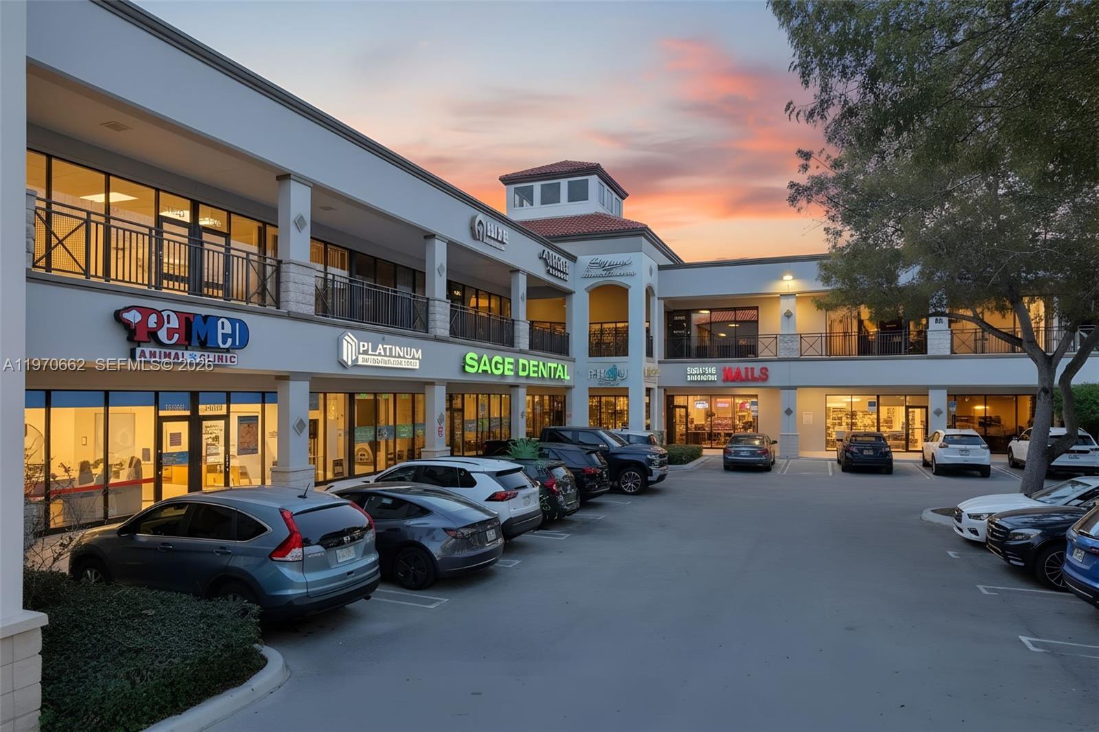 A two-story commercial building with retail storefronts and a parking lot at sunset — 12338 SW 127, Miami FL 33186, MIAMI, FL