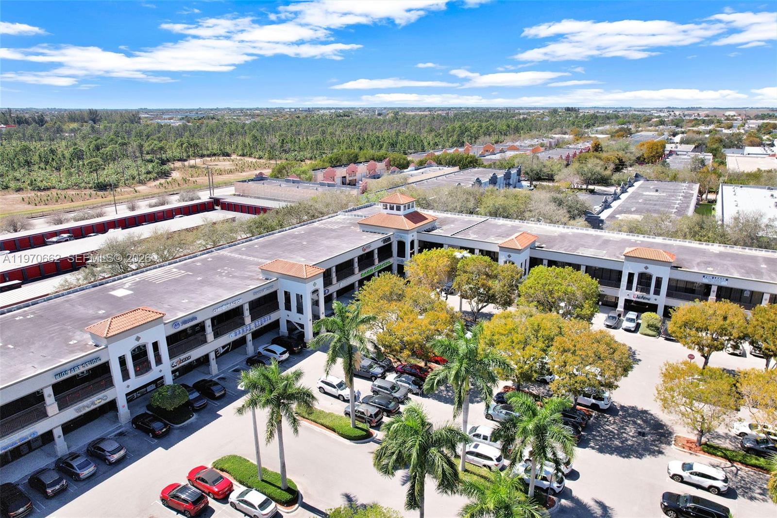 An aerial view shows a two-story commercial plaza with a central parking lot and trees — 12338 SW 127, Miami FL 33186, MIAMI, FL