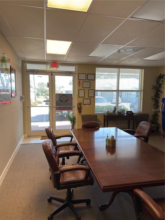 A conference room features a large wooden table, rolling leather chairs, and a glass-paned entrance — 2563 N TOLEDO BLADE BOULEVARD UNIT 2, NORTH PORT, FL