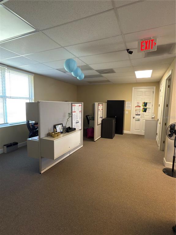 An office space features cubicle partitions, beige walls, carpeted flooring, and a white door — 2563 N TOLEDO BLADE BOULEVARD UNIT 2, NORTH PORT, FL