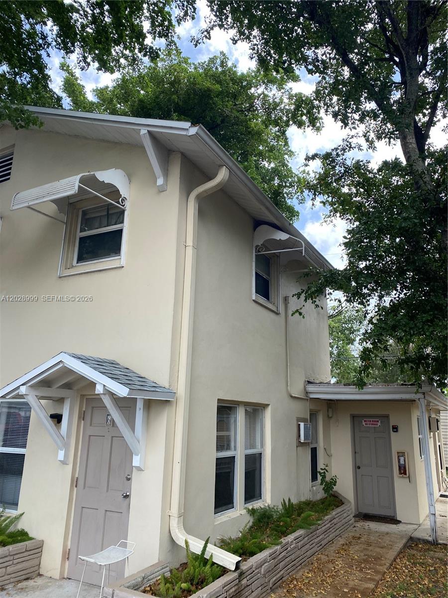 The exterior of a two-story beige building features a small porch and two doors — 26 SE 13th Ter # 7, Dania Beach FL 33004, DANIA BEACH, FL