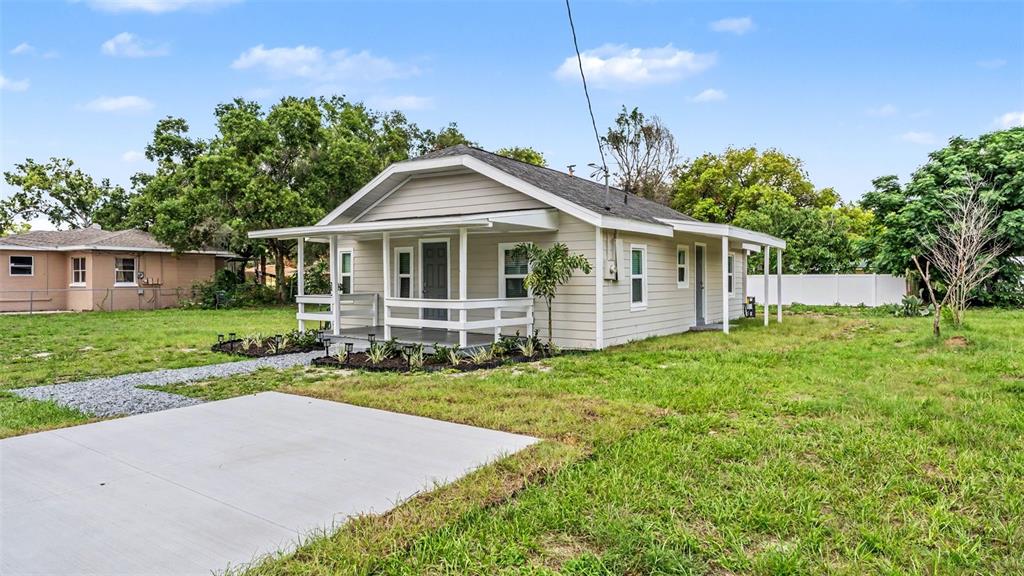A single-story house with light-colored siding, a front porch, and a concrete driveway — 820 26TH STREET NW, WINTER HAVEN, FL