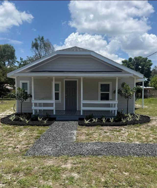 A single-story house with light gray siding, a front porch, and a gravel walkway — 820 26TH STREET NW, WINTER HAVEN, FL