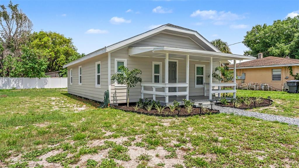 A light-colored, single-story house with a front porch and a gravel walkway — 820 26TH STREET NW, WINTER HAVEN, FL