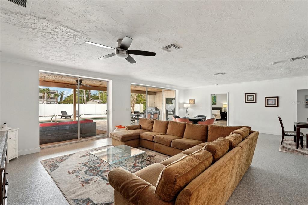A spacious living room features a large brown sectional, a glass coffee table, and sliding doors — 55 N WASHINGTON DRIVE, SARASOTA, FL
