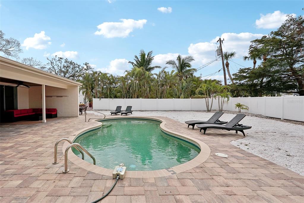 A backyard features a kidney-shaped swimming pool, a paved patio, and lounge chairs — 55 N WASHINGTON DRIVE, SARASOTA, FL