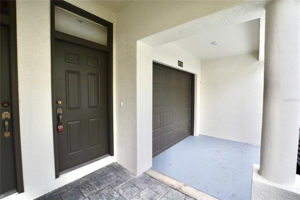 An exterior view shows a dark brown front door and a garage entrance — 858 NORMANDY TRACE ROAD, TAMPA, FL