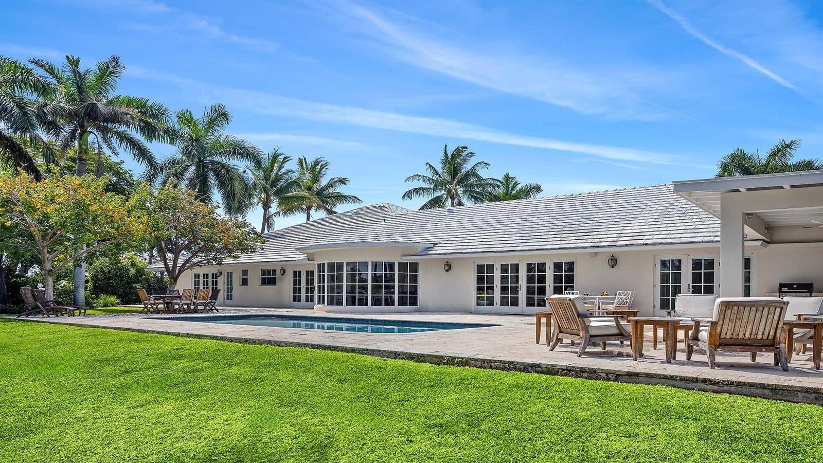 A single-story white house with a swimming pool and patio in a grassy backyard — 335 Old School Road, Gulf Stream FL 33483, GULF STREAM, FL