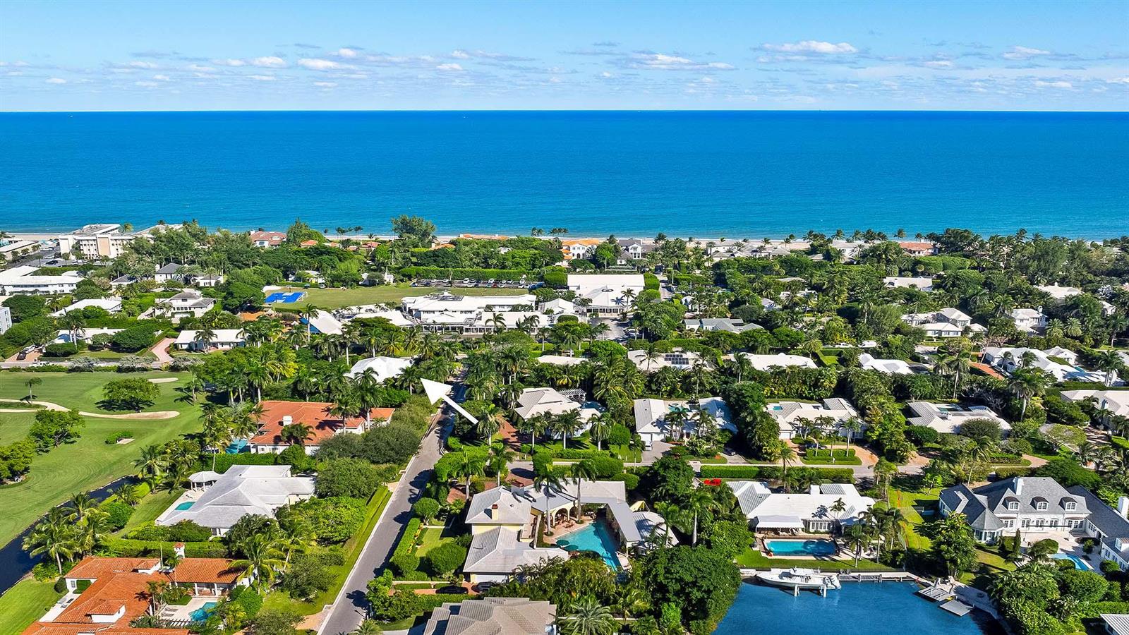 An aerial view shows a coastal neighborhood with houses, swimming pools, and a nearby beach — 335 Old School Road, Gulf Stream FL 33483, GULF STREAM, FL