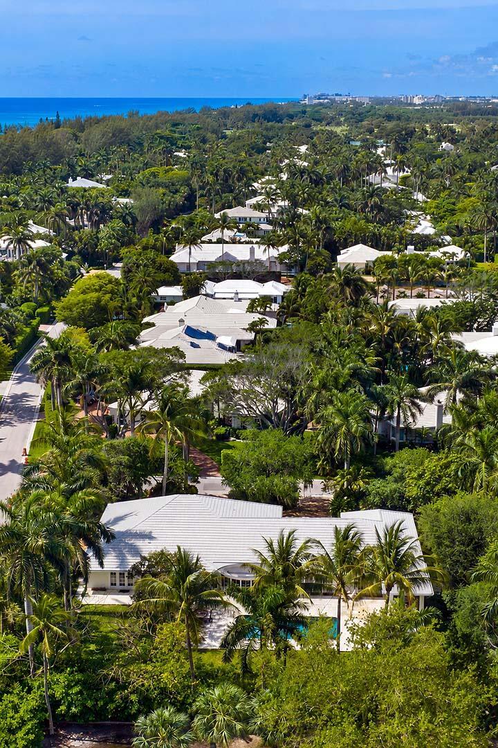 An aerial view of a residential neighborhood with white-roofed houses surrounded by lush tropical trees — 335 Old School Road, Gulf Stream FL 33483, GULF STREAM, FL