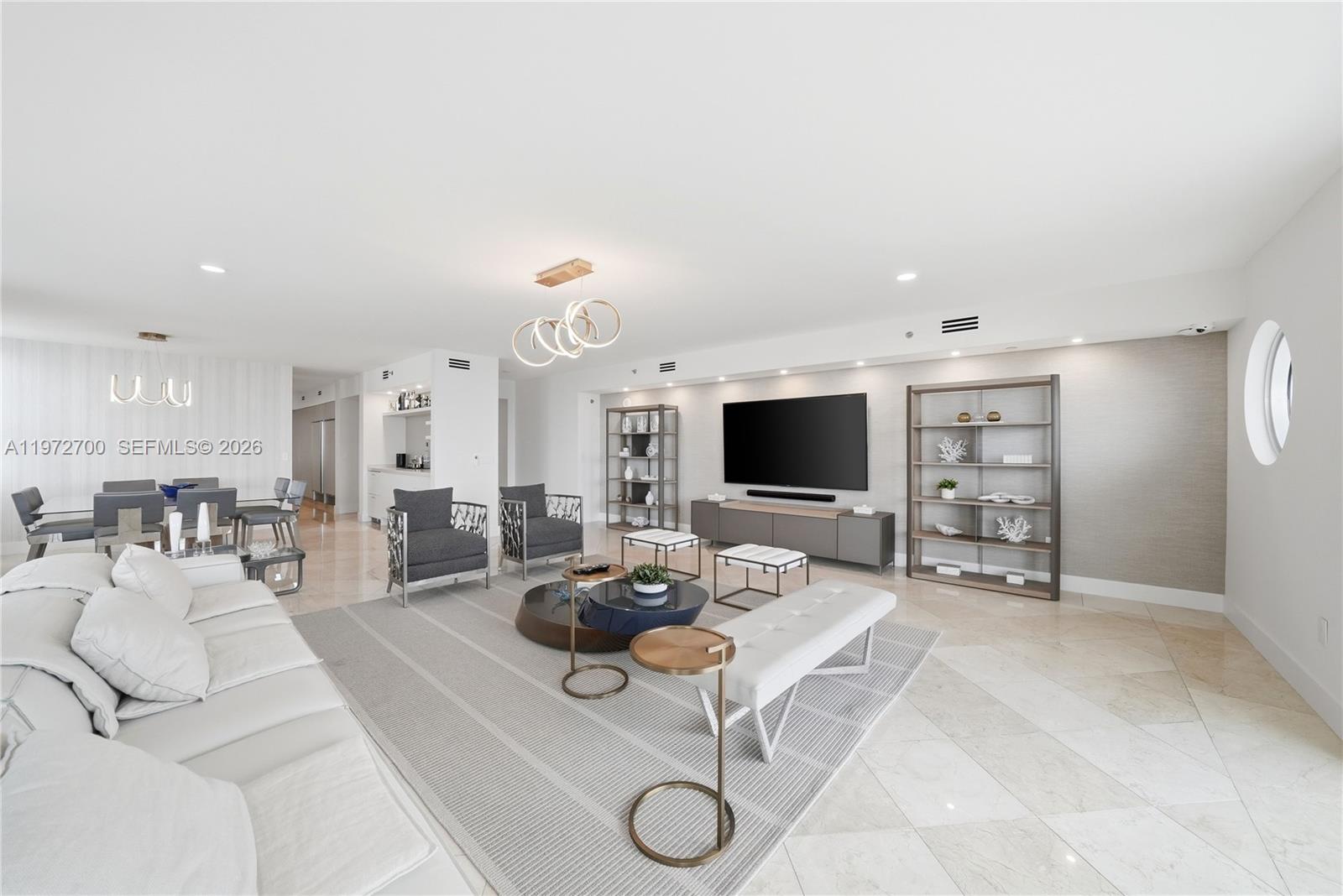 A modern, open-concept living and dining area features white tile floors and neutral decor — 5801 Collins Ave # 700, Miami Beach FL 33140, MIAMI BEACH, FL