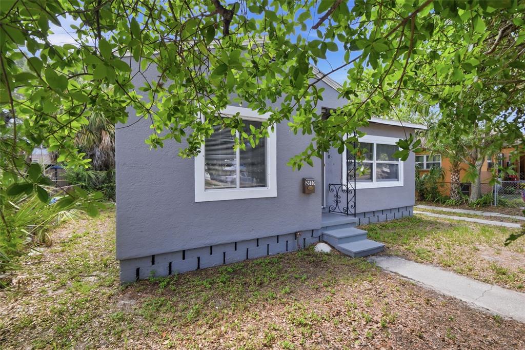 A gray, single-story house with white window trim and a small concrete front porch — 2610 DR MARTIN LUTHER KING JR STREET S, ST PETERSBURG, FL