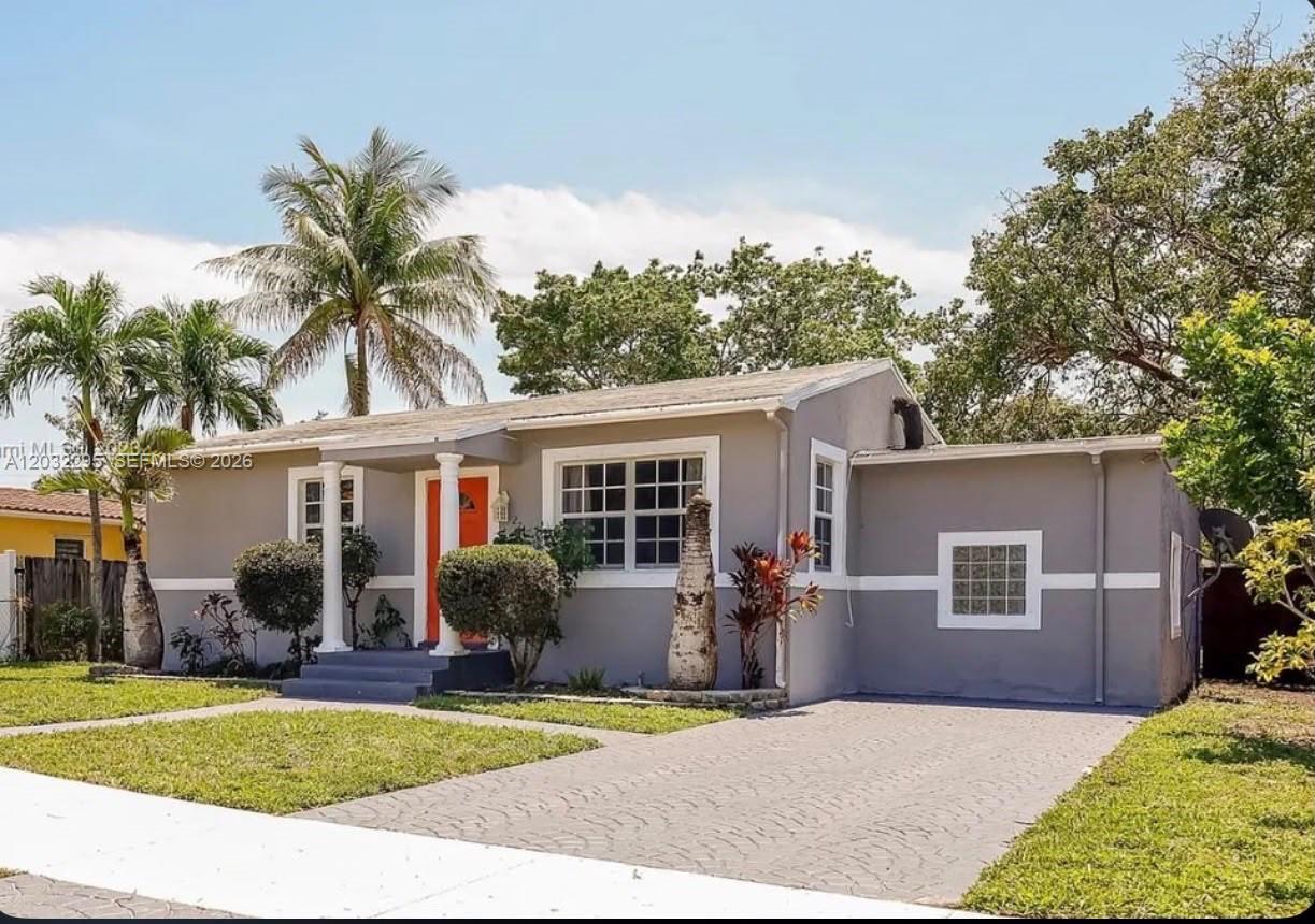 A single-story gray house with a paved driveway, orange front door, and glass block window — 2740 Dewey St, Hollywood FL 33020, HOLLYWOOD, FL